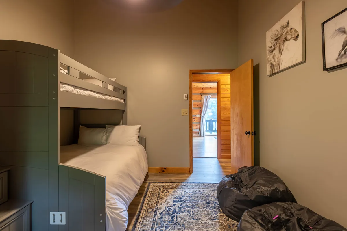 A cozy interior room designed for kids, featuring a bunk bed, soft bean bags, and playful artwork. The space radiates warmth and fun, inviting children to read, play, or unwind after a day of adventures.